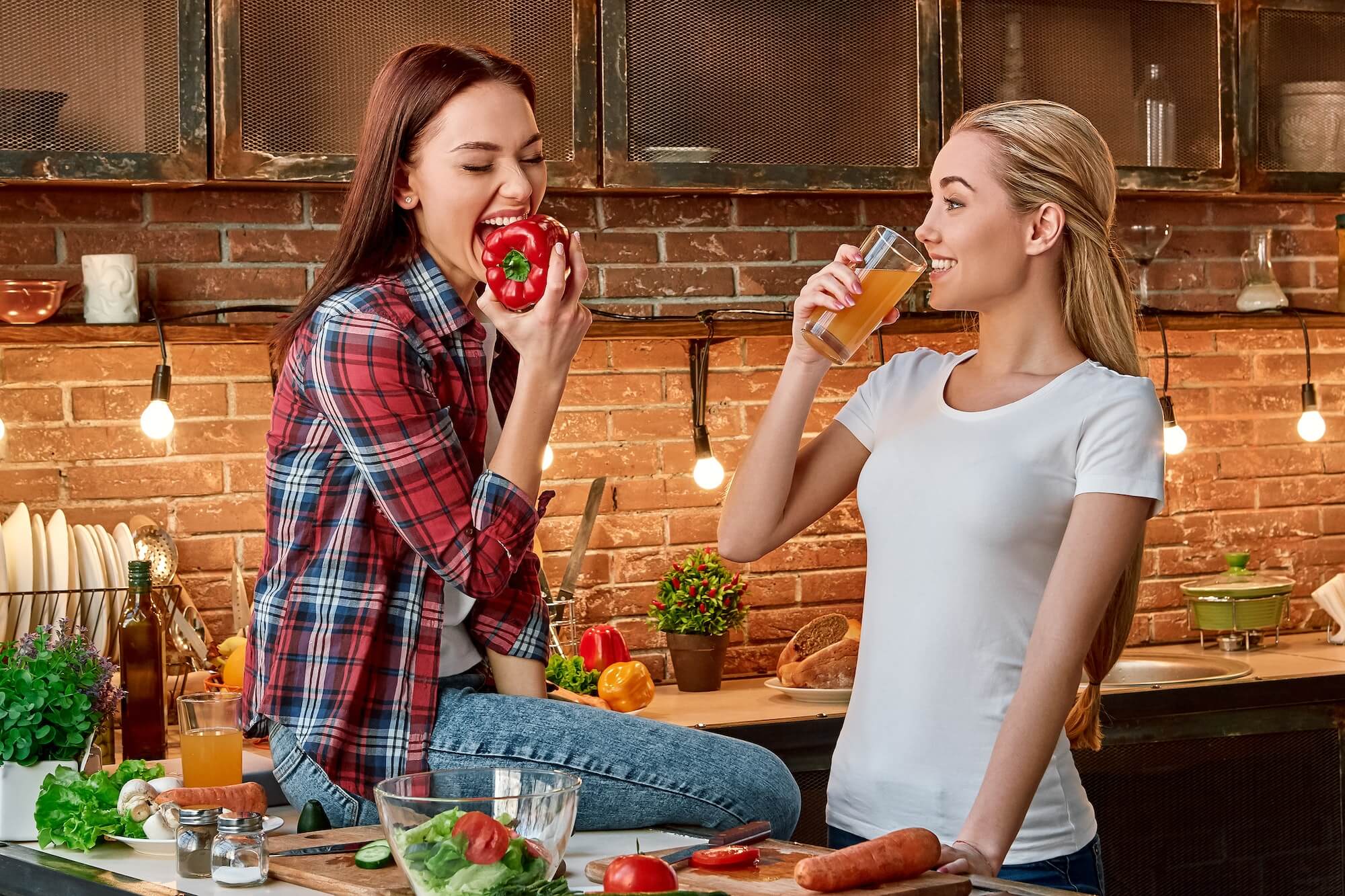 eat-well-to-be-well-young-female-friends-preparing-together-healthy-meal-in-modern-kitchen-cozy-1.jpg